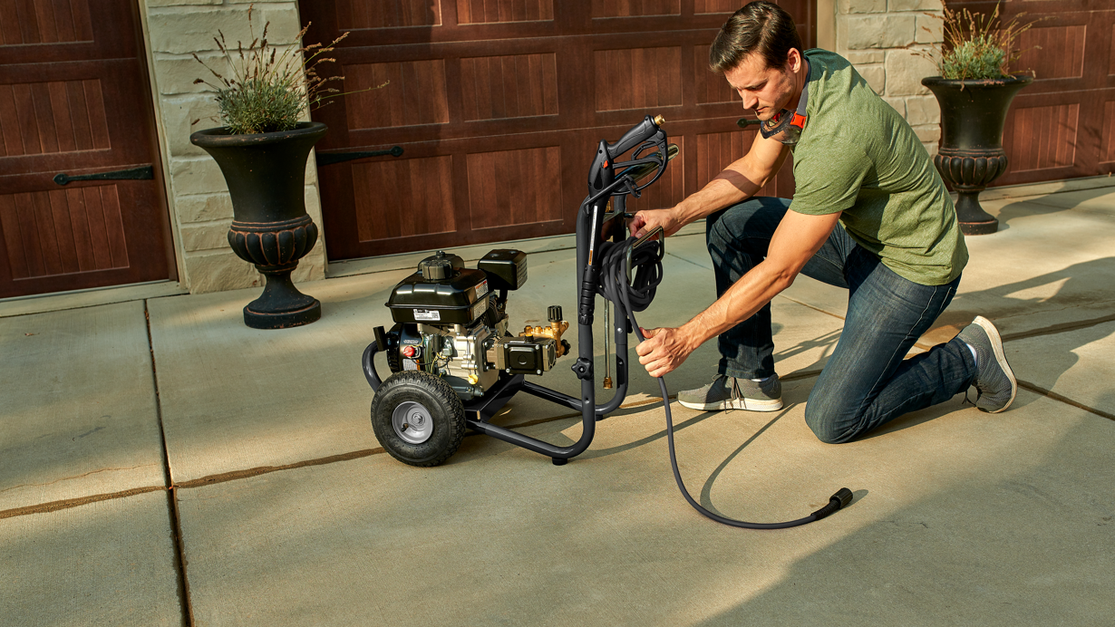 Man wrapping up a cord for a gas pressure washer powered by a Briggs & Stratton Single-Cylinder Horizontal Shaft utility engine